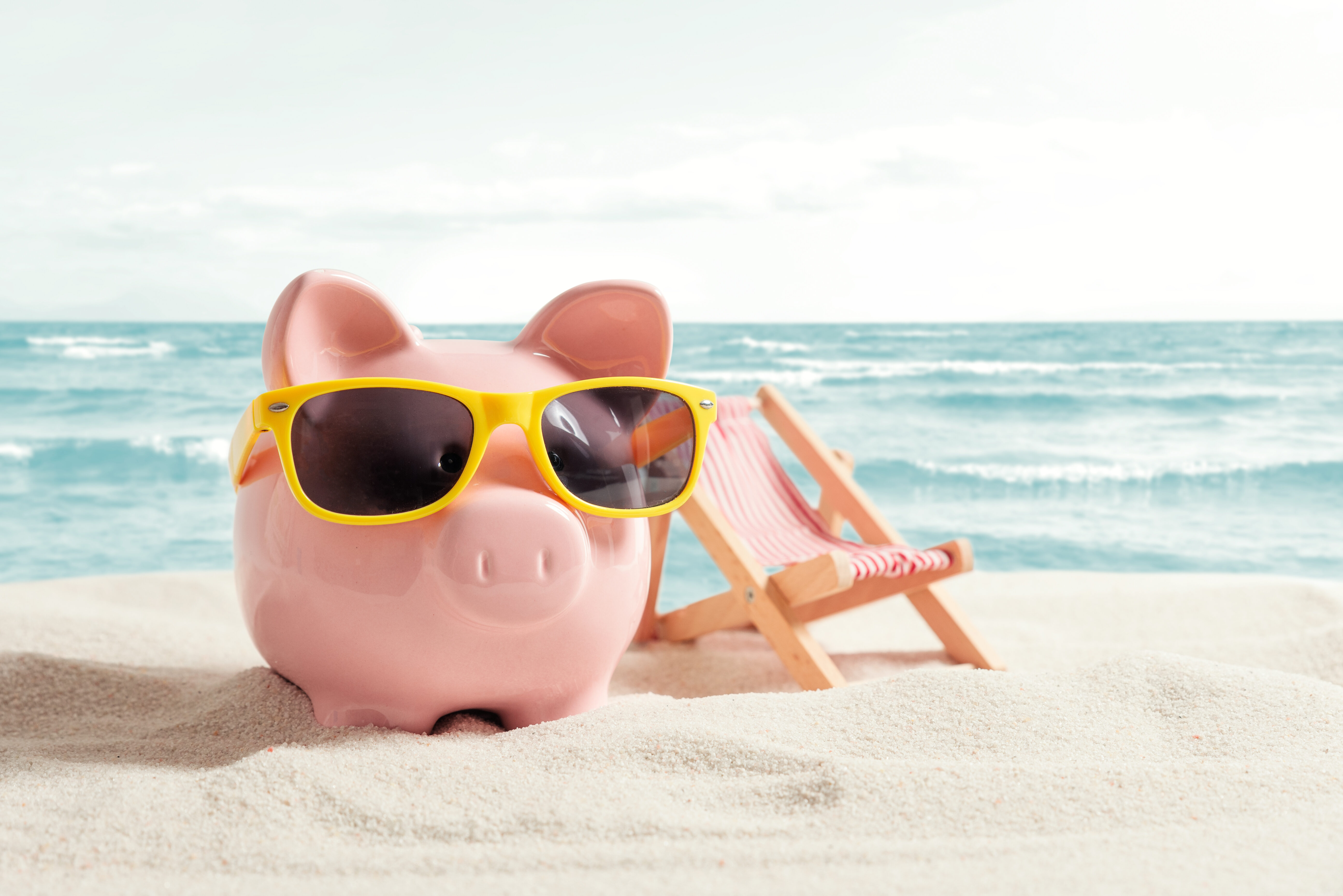 Sparschwein entspannt im Urlaub. Geld sparen