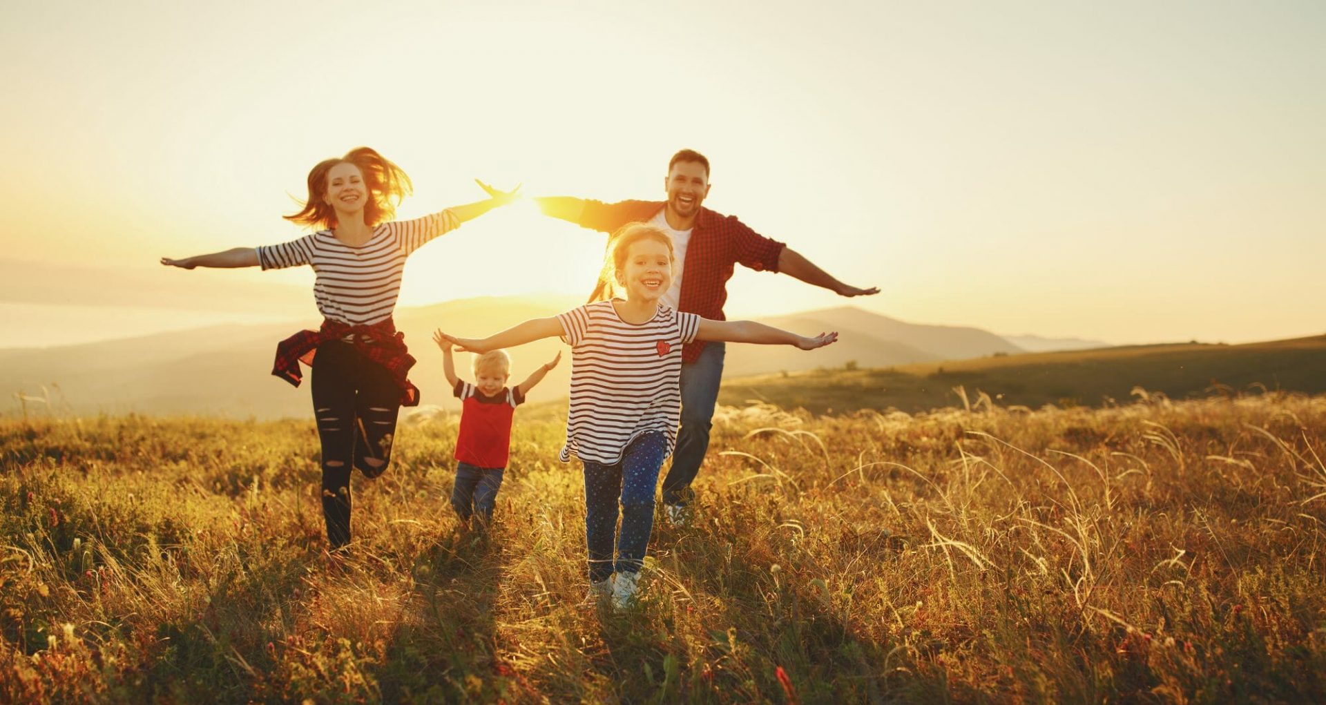 Glückliche Familie: Mutter, Vater, Sohn und Tochter in der Natur