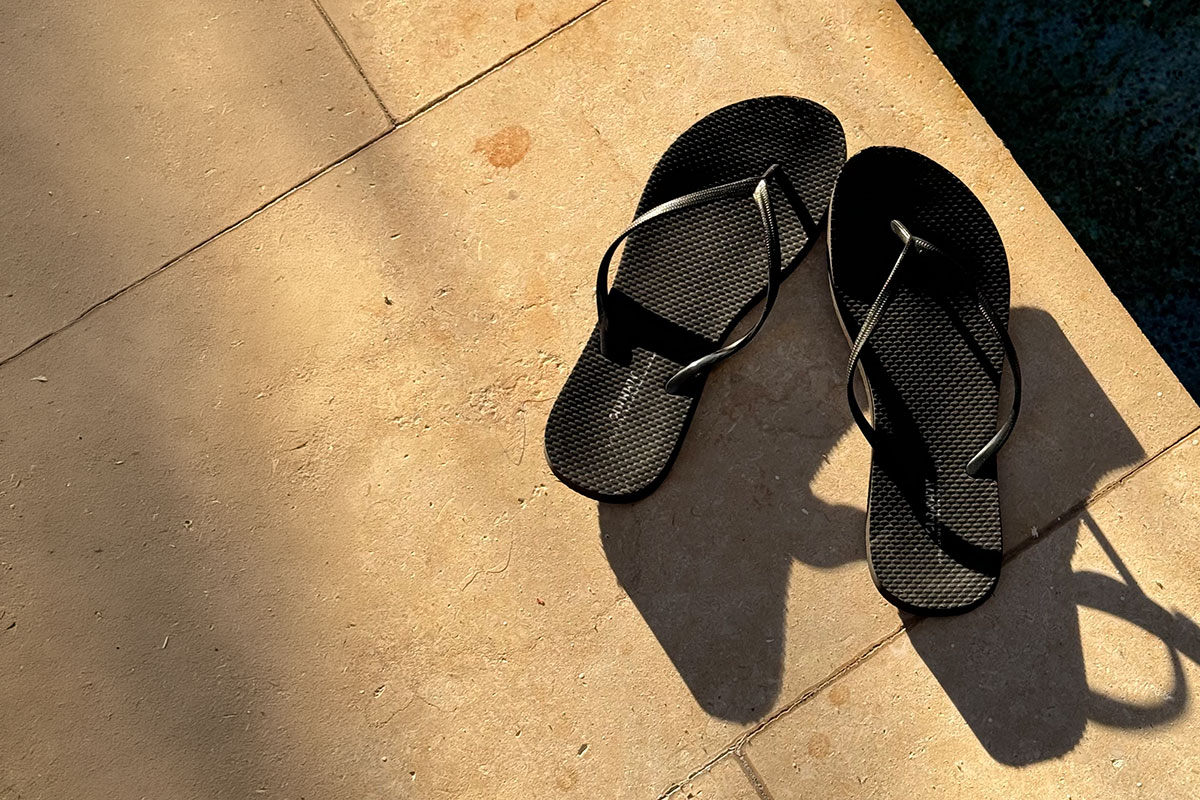 Schwarze Flip Flops am Pool