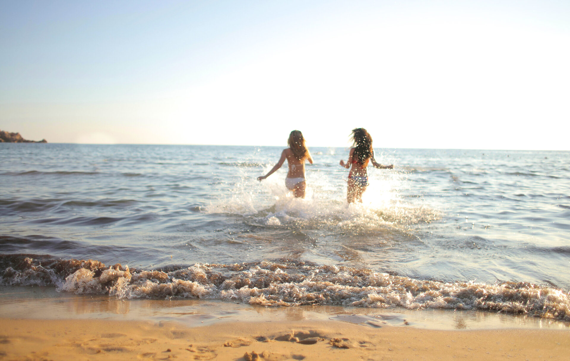 Zwei Mädchen rennen ins Meer
